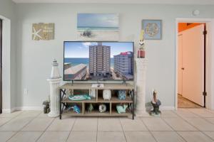 a living room with a tv on a wall at Gulf Tower 3C by Vacation Homes Collection in Gulf Shores +38 photos