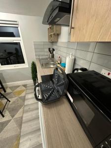 uma cozinha com uma bancada com um lavatório e uma bancada com um sidx em DVM escape Flat 2 em Bristol