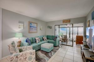 a living room with a blue couch and a balcony at Gulf Tower 3C by Vacation Homes Collection in Gulf Shores