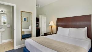 a bedroom with a bed and a sink and a mirror at Crystal Bay Historic Hotel in St. Petersburg