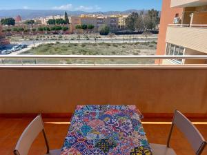 a table and chairs on a balcony with a view at Apartamento El Ingenio con balcón y aparcamiento en Almería - Alborania in Almería