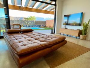 um grande sofá de couro castanho numa sala de estar em Bungalow + Piscina independiente em La Oliva