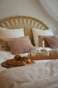 uma cama com uma bandeja de pão e velas em Domaine des cyprès em Vaudrimesnil
