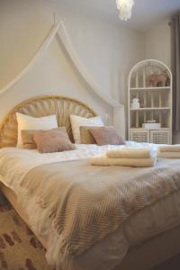 a bedroom with a large white bed with pillows at Domaine des cyprès in Vaudrimesnil