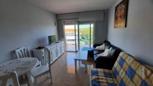 ein Wohnzimmer mit einem Sofa und einem Tisch in der Unterkunft Enjoy the swimming pool and relax in Cap Salou in Salou