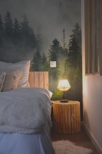 ein Schlafzimmer mit einem Bett und einem Tisch mit einer Lampe in der Unterkunft Domaine des cyprès in Vaudrimesnil
