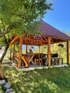 a wooden gazebo with a man sitting in it at Rupa Guest House in Theth