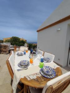 a wooden table with plates and glasses on a patio at Villa Jana in Porto Pollo +63 photos
