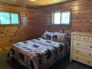 um quarto com uma cama num chalé de madeira em Gresham Shores-Hungry Bear em Arbor Vitae