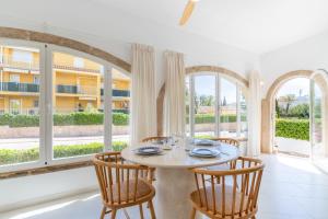 Chalet independiente a 50 metros de Cala Blanca في خافيا: غرفة طعام مع طاولة وكراسي ونوافذ