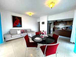 a living room with a black table and red chairs at Private beach front Apartment in Juan Dolio in Los Corrales