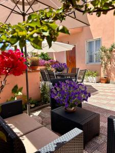 eine Terrasse mit einem Tisch, Stühlen und Blumen in der Unterkunft Anthea B&B in Ercolano