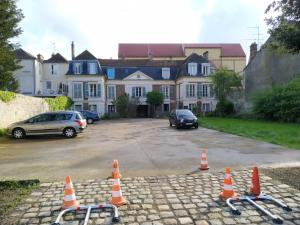 ein Parkplatz mit orangefarbenen Kegeln vor einem Haus in der Unterkunft Studio avec jardin a Corbeil-Essonne in Corbeil-Essonnes
