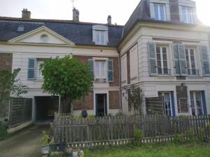 ein Haus mit einem Zaun und einem Baum im Hof in der Unterkunft Studio avec jardin a Corbeil-Essonne in Corbeil-Essonnes