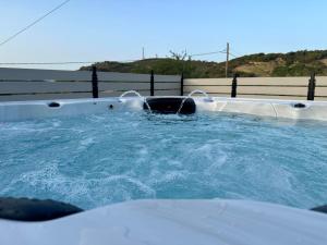 a hot tub with two faucets and water at Villa Eftychia Serene Getaway with Hot Tub in a Quiet Location in Kissamos