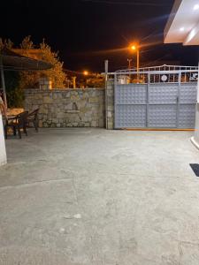 a patio at night with a fence and a table at Guest House Kloen in Vlorë