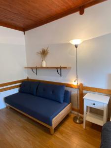 a living room with a blue couch and a table at Pension Hamry in Vranov nad Dyjí