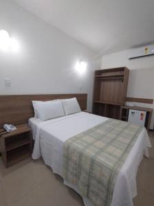 um quarto com uma grande cama branca num quarto em Hotel Algas Marinhas em Aracaju