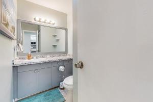 a bathroom with a sink and a toilet and a mirror at Centrally located dog-friendly home with beach gear & patio - snowbird-friendly in Palm Coast +15 photos