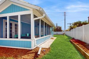 a blue house with a large sliding glass door at Centrally located dog-friendly home with beach gear & patio - snowbird-friendly in Palm Coast