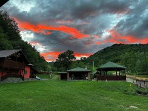 a cloudy sky with a gazebo in a yard at Cabana Bombonel in Gura Teghii