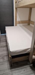 ein kleines weißes Bett in einem Zimmer in der Unterkunft Appartement neuf classé pour 4 in Huez