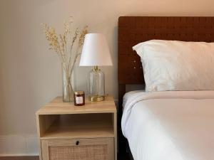 een bed met een lamp op een nachtkastje naast een bed bij Cozy & charming Downtown condo! in Toronto