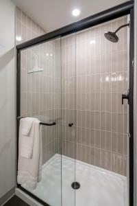 a shower with a glass door in a bathroom at The Local Motel & Shops in Eugene +52 photos