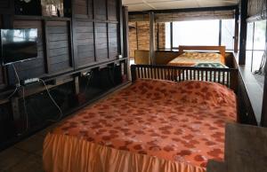 Mariuti的住宿－LE ROCHER DE TAHITI，一间卧室配有两张床和一台平面电视