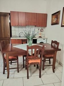 uma cozinha com uma mesa de jantar em madeira e cadeiras em Casetta del’600 in antico ortale salentino em Maglie