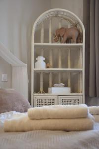 uma prateleira branca com um elefante de brinquedo em cima de uma cama em Domaine des cyprès em Vaudrimesnil