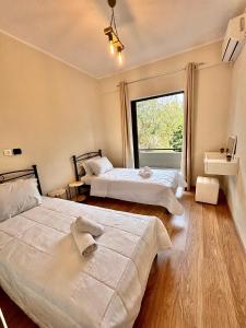 2 camas en una habitación con ventana grande en Elite84Kimolia, en Mastambás