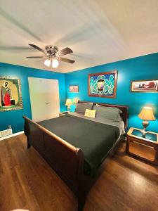 a bedroom with a large bed with blue walls at Family Friendly Downtown Home - Private Yard & Grill - Location, Location, Location! in Athens