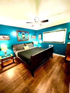 a bedroom with a large bed with blue walls at Family Friendly Downtown Home - Private Yard & Grill - Location, Location, Location! in Athens