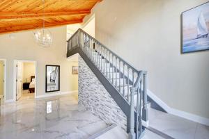 eine Treppe in einem Wohnzimmer mit einer Ziegelwand in der Unterkunft Luxury 5BR & 3BA Villa Walk to Hollywood Beach in Hollywood
