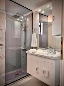 a bathroom with a shower and a sink and a mirror at Elite84Kimolia in Mastambás