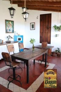 una sala da pranzo con tavolo e sedie in legno di Hotel Bugamvillas Tapalpa a Tapalpa