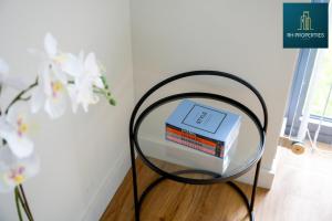 uma mesa de vidro com uma pilha de livros sobre ela em Stylish 2 Bedroom Apartment em Manchester