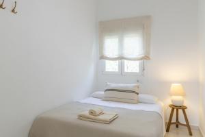 una camera da letto bianca con un letto e asciugamani di Chalet independiente a 50 metros de Cala Blanca a Jávea