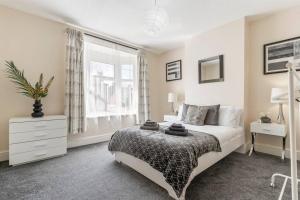 a white bedroom with a bed and a window at Spacious 3 Bedroom House - FREE PARKING in Leicester