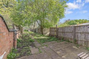 an alley with a fence and a tree at Spacious 3 Bedroom House - FREE PARKING in Leicester