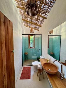 a bathroom with a tub and a toilet and a sink at Casa Tuco - Cumuruxatiba in Cumuruxatiba