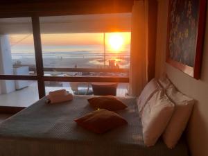 1 dormitorio con 1 cama y vistas al océano en Pousada Beira Mar - Suítes Frente ao mar, en Torres