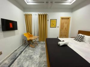 1 dormitorio con 1 cama, 1 mesa y 1 silla en Dastak Hotel, en Islamabad