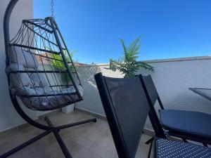 a bird cage sitting on a chair on a balcony at Apartment New Chic in Supetar