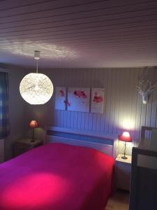 1 dormitorio con 1 cama rosa y 2 lámparas en Chalet Ardenne Routy, en Rochehaut