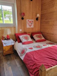 a bedroom with two beds with red sheets and a window at appartement Gérardmer proche lac , borne vidéo, espace exterieur in Gérardmer