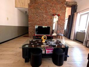 Appartements de Charme DADOU MONS BELGIUM في مون: غرفة معيشة مع طاولة قهوة وتلفزيون