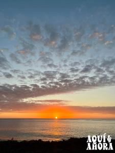 a sunset over the ocean with the sun in the sky at Aqui Ahora at Villa Verde in San Andrés