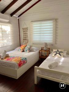 a bedroom with two beds and a window at Aqui Ahora at Villa Verde in San Andrés